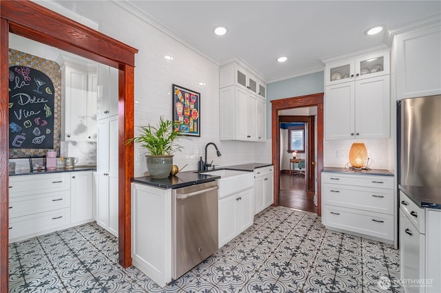 9316 7th Ave S, Seattle, WA 98108 - kitchen with stainless steel appliances, a sink, tasteful backsplash, dark countertops, and white cabinetry