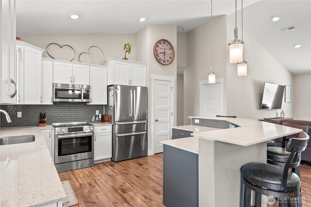 3 Kingfisher Rd, Twisp, WA 98856 - kitchen with appliances with stainless steel finishes, a sink, light wood-style floors, decorative backsplash, and lofted ceiling