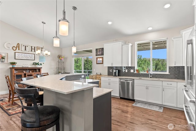 3 Kingfisher Rd, Twisp, WA 98856 - kitchen with stainless steel dishwasher, a sink, tasteful backsplash, a chandelier, and a kitchen island with sink