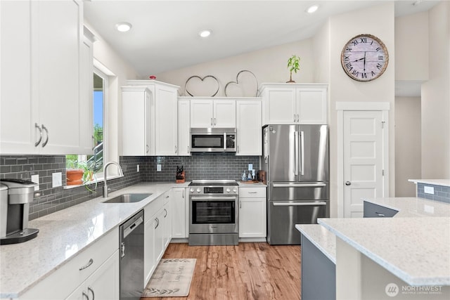 3 Kingfisher Rd, Twisp, WA 98856 - kitchen featuring appliances with stainless steel finishes, a sink, light wood-style floors, white cabinetry, and tasteful backsplash