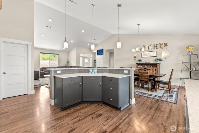 3 Kingfisher Rd, Twisp, WA 98856 - kitchen with lofted ceiling, wood finished floors, light countertops, a kitchen island, and hanging light fixtures