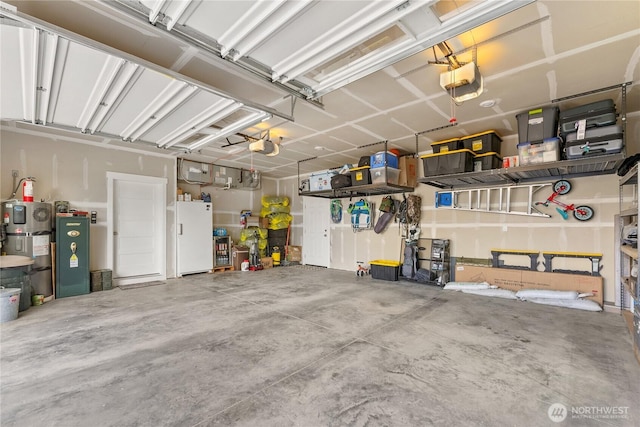3 Kingfisher Rd, Twisp, WA 98856 - garage featuring freestanding refrigerator, a garage door opener, and secured water heater
