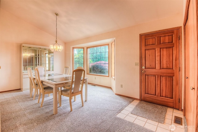 703 Tanarae Pl, Yakima, WA 98908 - dining area with light colored carpet, vaulted ceiling, a chandelier, and light tile patterned flooring