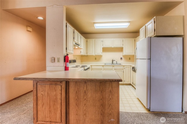 703 Tanarae Pl, Yakima, WA 98908 - kitchen with white appliances, a peninsula, light countertops, under cabinet range hood, and light floors