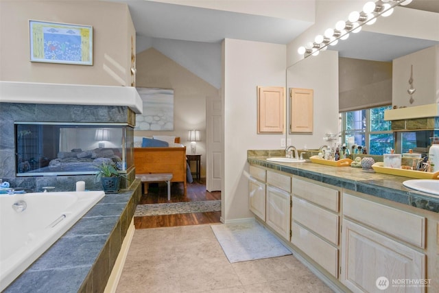 9042 Gleneagle Dr, Blaine, WA 98230 - full bath featuring double vanity, tiled tub, lofted ceiling, and a multi sided fireplace