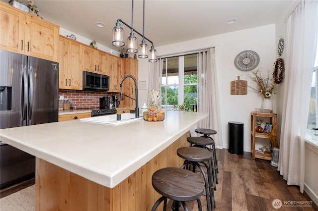 515 Mitchell St, Sumas, WA 98295 - kitchen with stainless steel refrigerator with ice dispenser, backsplash, dark wood-type flooring, light brown cabinetry, and a breakfast bar area
