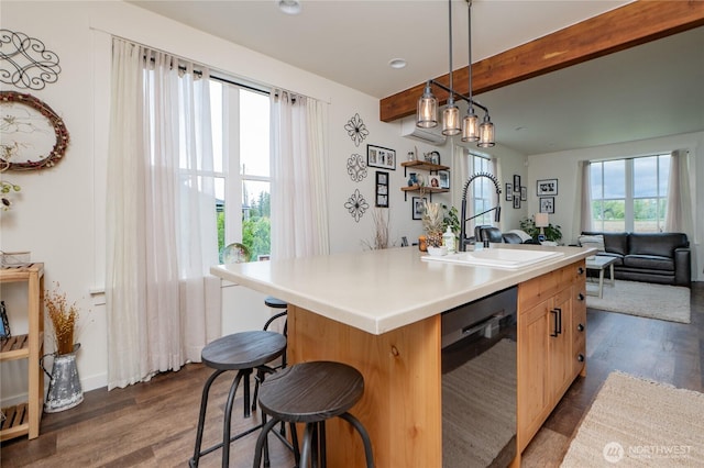 515 Mitchell St, Sumas, WA 98295 - kitchen featuring dishwashing machine, a sink, dark wood-style flooring, beamed ceiling, and a kitchen island with sink