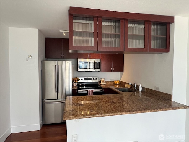 1105 Spring Unit 1309, Seattle, WA 98104 - kitchen featuring stainless steel appliances, a sink, a peninsula, dark stone countertops, and dark wood finished floors