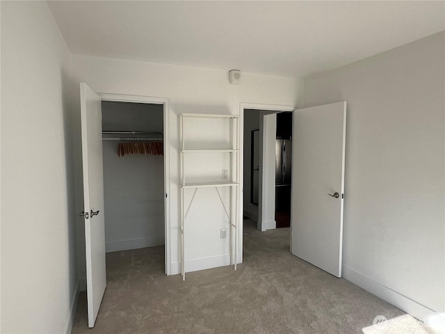 1105 Spring Unit 1309, Seattle, WA 98104 - unfurnished bedroom featuring a walk in closet, carpet flooring, a closet, and freestanding refrigerator