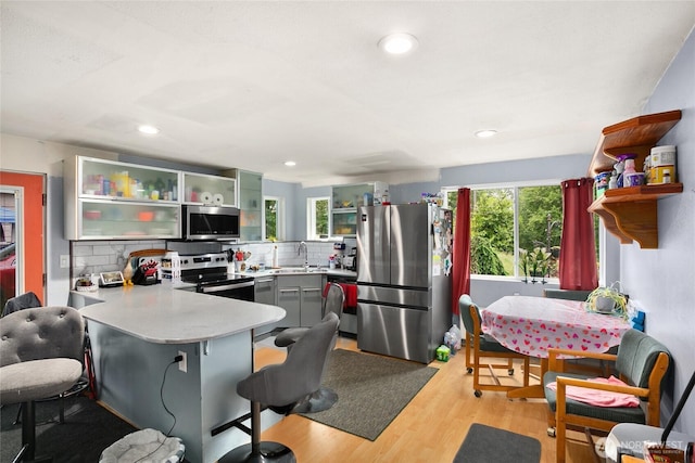 7431 S 132nd St, Seattle, WA 98178 - kitchen with appliances with stainless steel finishes, open shelves, a peninsula, light countertops, and tasteful backsplash