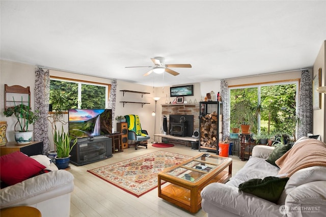 7431 S 132nd St, Seattle, WA 98178 - living room with a ceiling fan, wood finished floors, and a wood stove