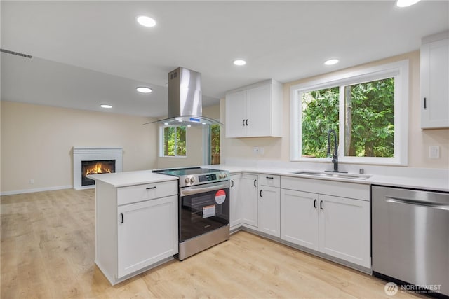 2021 224th Pl NE, Sammamish, WA 98074 - kitchen featuring stainless steel appliances, island range hood, a sink, a peninsula, and white cabinets