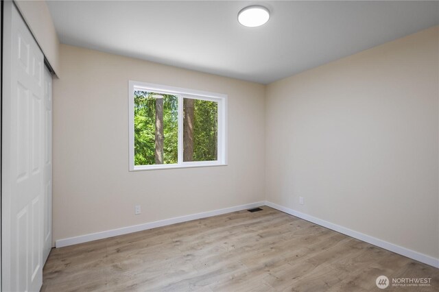 2021 224th Pl NE, Sammamish, WA 98074 - unfurnished bedroom featuring a closet, baseboards, and wood finished floors