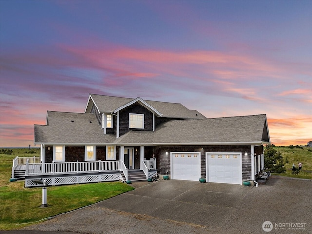 234 26th St NW, Long Beach, WA 98631 - view of front facade featuring a garage, concrete driveway, covered porch, a shingled roof, and a front yard