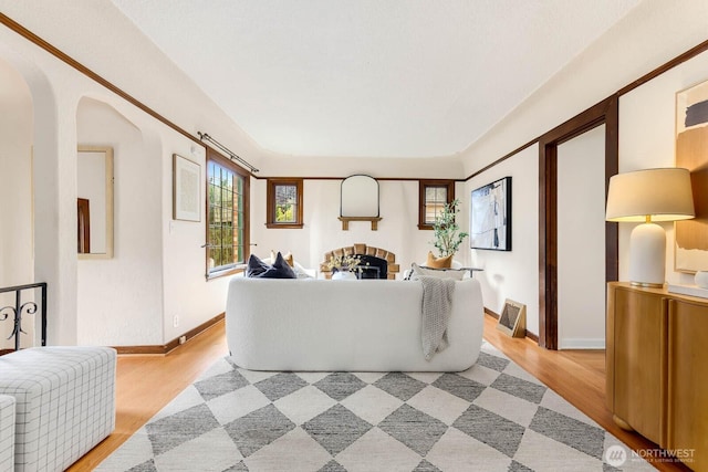 1214 NE 98th St, Seattle, WA 98115 - living area with light wood-type flooring, arched walkways, and baseboards