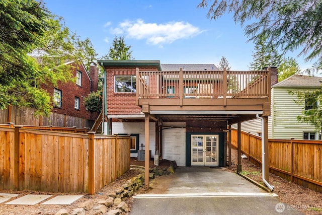 1214 NE 98th St, Seattle, WA 98115 - back of property featuring a wooden deck, french doors, a fenced backyard, and brick siding