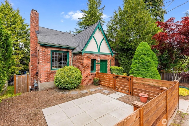 1214 NE 98th St, Seattle, WA 98115 - view of front of property with a chimney, a patio, roof with shingles, and brick siding