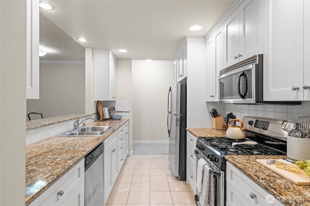 1310 Old Fairhaven Pkwy Unit 102, Bellingham, WA 98225 - kitchen featuring stainless steel appliances, a sink, crown molding, baseboards, and backsplash