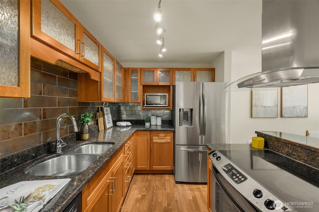11058 NE 33rd Pl Unit B9, Bellevue, WA 98004 - kitchen with wall chimney exhaust hood, stainless steel appliances, a sink, brown cabinetry, and light wood finished floors
