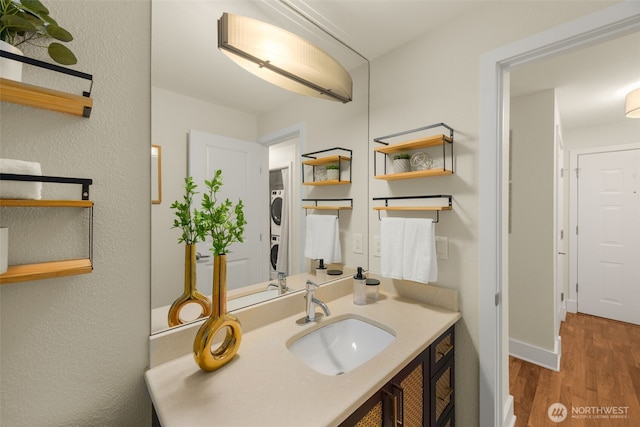 11058 NE 33rd Pl Unit B9, Bellevue, WA 98004 - bathroom with stacked washer / drying machine, wood finished floors, vanity, and baseboards