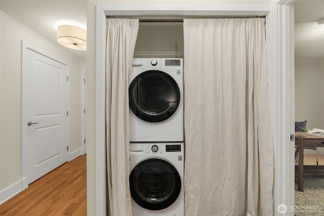 11058 NE 33rd Pl Unit B9, Bellevue, WA 98004 - laundry area featuring stacked washer and clothes dryer, wood finished floors, and baseboards
