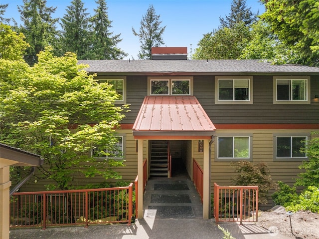 11058 NE 33rd Pl Unit B9, Bellevue, WA 98004 - view of front facade featuring metal roof, stairs, and a chimney
