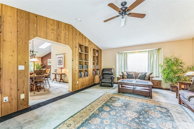 3220 N Pacific Ave, Kelso, WA 98626 - living room featuring carpet flooring, lofted ceiling, wooden walls, ceiling fan, and built in shelves