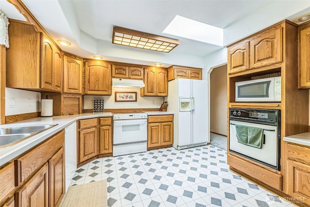 3220 N Pacific Ave, Kelso, WA 98626 - kitchen featuring white appliances, under cabinet range hood, and brown cabinetry