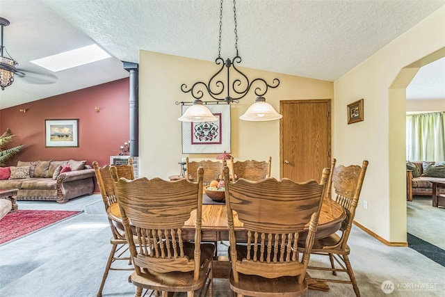 3220 N Pacific Ave, Kelso, WA 98626 - dining space with carpet, vaulted ceiling, arched walkways, a textured ceiling, and a skylight