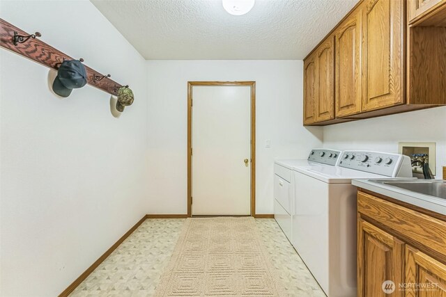 3220 N Pacific Ave, Kelso, WA 98626 - washroom with light flooring, washer and dryer, cabinet space, baseboards, and a textured ceiling