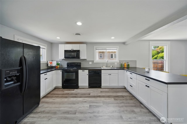 1128 W Elm St, Walla Walla, WA 99362 - kitchen featuring black appliances, a peninsula, a sink, dark countertops, and white cabinets