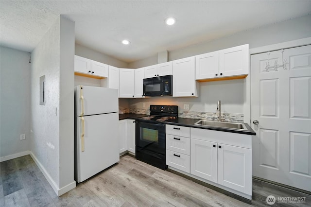 1128 W Elm St, Walla Walla, WA 99362 - kitchen with black appliances, a sink, light wood-type flooring, white cabinets, and baseboards