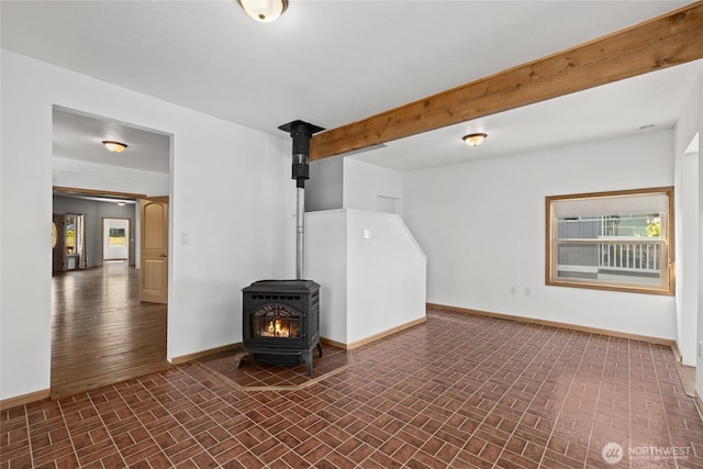 706 S A St, Roslyn, WA 98941 - unfurnished living room featuring brick patterned flooring, baseboards, and a wood stove