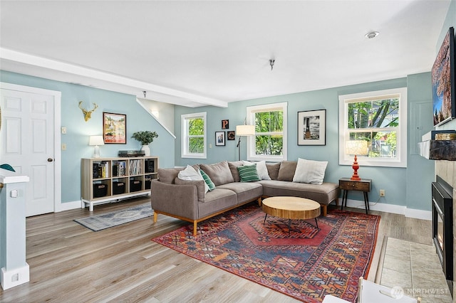 490 Madison Ave N Unit 202, Bainbridge Island, WA 98110 - living room featuring wood finished floors, a tiled fireplace, and baseboards