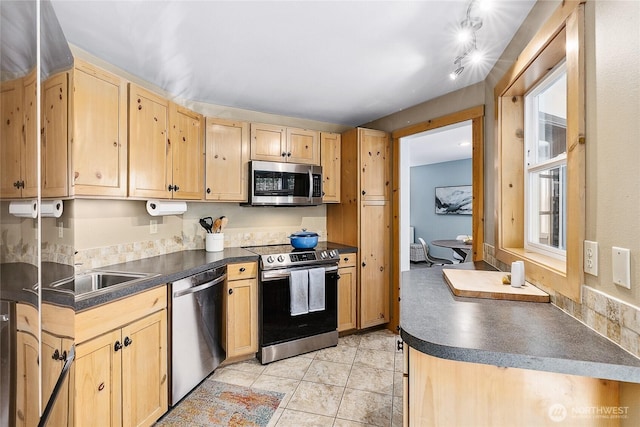 490 Madison Ave N Unit 202, Bainbridge Island, WA 98110 - kitchen with stainless steel appliances, dark countertops, light brown cabinets, a sink, and light tile patterned floors