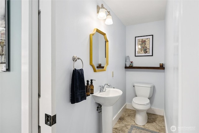 490 Madison Ave N Unit 202, Bainbridge Island, WA 98110 - half bathroom featuring toilet, tile patterned flooring, a sink, and baseboards