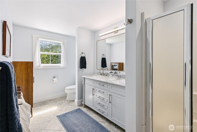 490 Madison Ave N Unit 202, Bainbridge Island, WA 98110 - bathroom with double vanity, baseboards, toilet, and a shower with door