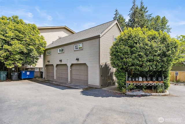 490 Madison Ave N Unit 202, Bainbridge Island, WA 98110 - view of home's exterior featuring an attached garage and asphalt driveway