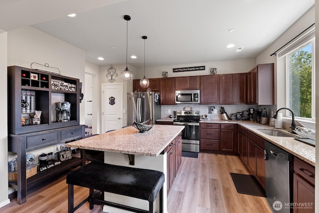 2225 Seringa Ave, Bremerton, WA 98310 - kitchen with stainless steel appliances, a sink, a kitchen island, light stone countertops, and recessed lighting