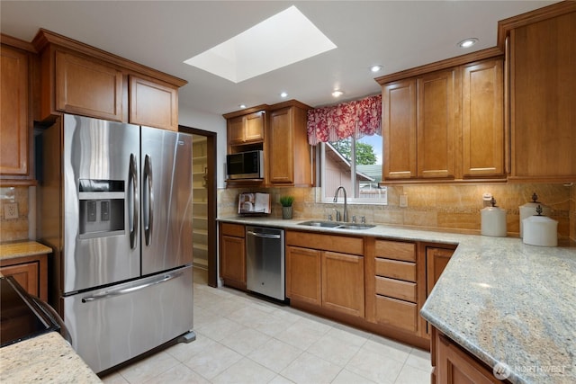 16801 Lakeside Dr S, Spanaway, WA 98387 - kitchen with a sink, stainless steel appliances, a skylight, brown cabinetry, and recessed lighting