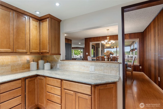 16801 Lakeside Dr S, Spanaway, WA 98387 - kitchen featuring tasteful backsplash, brown cabinetry, wood finished floors, a chandelier, and recessed lighting
