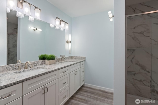16801 Lakeside Dr S, Spanaway, WA 98387 - bathroom with double vanity, a marble finish shower, wood finished floors, and baseboards