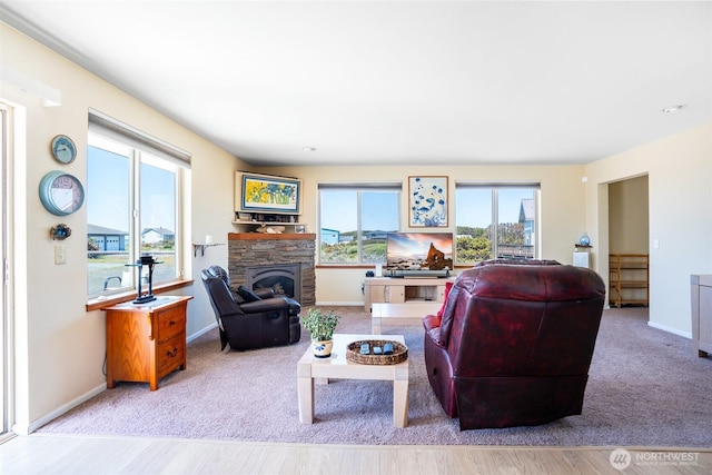 927 Pheasant Run, Westport, WA 98595 - carpeted living area featuring a stone fireplace, baseboards, and wood finished floors