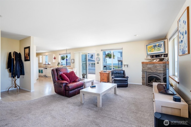 927 Pheasant Run, Westport, WA 98595 - living room featuring carpet floors, plenty of natural light, a fireplace, and baseboards