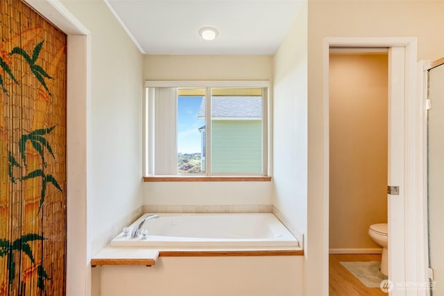 927 Pheasant Run, Westport, WA 98595 - full bathroom featuring toilet, a garden tub, and wood finished floors