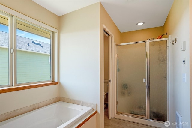 927 Pheasant Run, Westport, WA 98595 - full bath featuring a stall shower, a whirlpool tub, toilet, and wood finished floors