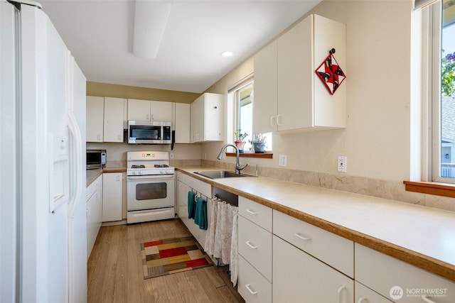 927 Pheasant Run, Westport, WA 98595 - kitchen with white appliances, a sink, healthy amount of natural light, and light wood-type flooring