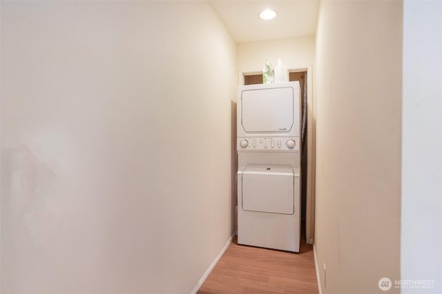 927 Pheasant Run, Westport, WA 98595 - washroom featuring stacked washer / drying machine, light wood finished floors, and baseboards