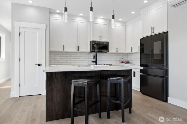 370 S Butterclam St SW, Ocean Shores, WA 98569 - kitchen with freestanding refrigerator, stainless steel microwave, a center island with sink, baseboards, and recessed lighting