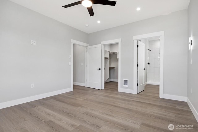 370 S Butterclam St SW, Ocean Shores, WA 98569 - unfurnished bedroom featuring light wood finished floors, baseboards, a spacious closet, ensuite bath, and ceiling fan